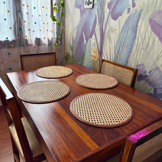 Round rattan table mats placed on a wooden dining table, with the mats displaying a natural rattan pattern.